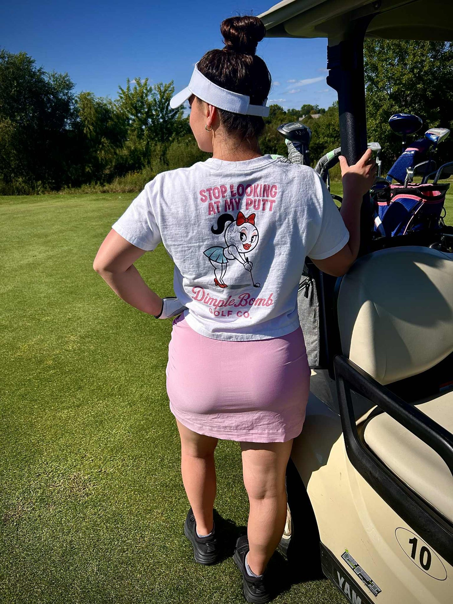 Dimple Golf Shirt White on a Lady leaning of Golf Cart