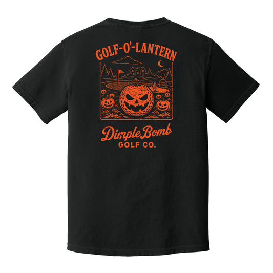A black short-sleeve t-shirt shown from the back, featuring a prominent orange graphic print with jack-o'-lanterns, a golf course scene, and the text 'GOLF-O'-LANTERN' and 'Dimple Bomb GOLF CO.'.