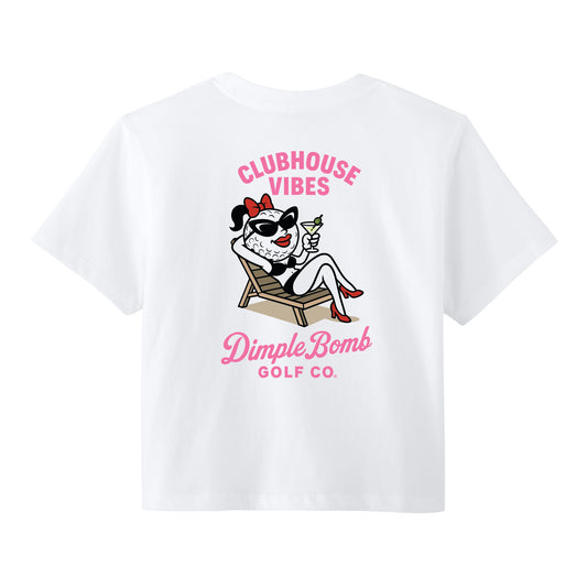 White women’s golf graphic tee featuring Ms. Dimple lounging in a chair with sunglasses and a martini, “Clubhouse Vibes” text, and the Dimple Bomb Golf Co. logo on the back.
