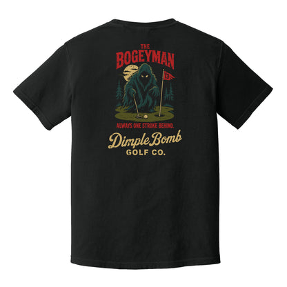 A black short-sleeve t-shirt shown from the back, featuring a large graphic print of a mysterious bogeyman on a golf green with the text 'The Bogeyman', 'Always One Stroke Behind.', and 'DimpleBomb Golf Co.