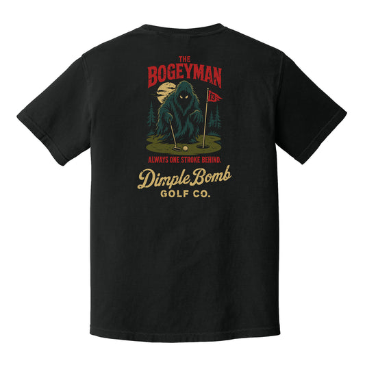 A black short-sleeve t-shirt shown from the back, featuring a large graphic print of a mysterious bogeyman on a golf green with the text 'The Bogeyman', 'Always One Stroke Behind.', and 'DimpleBomb Golf Co.